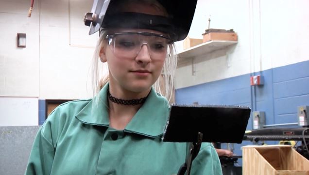 student with a welding mask